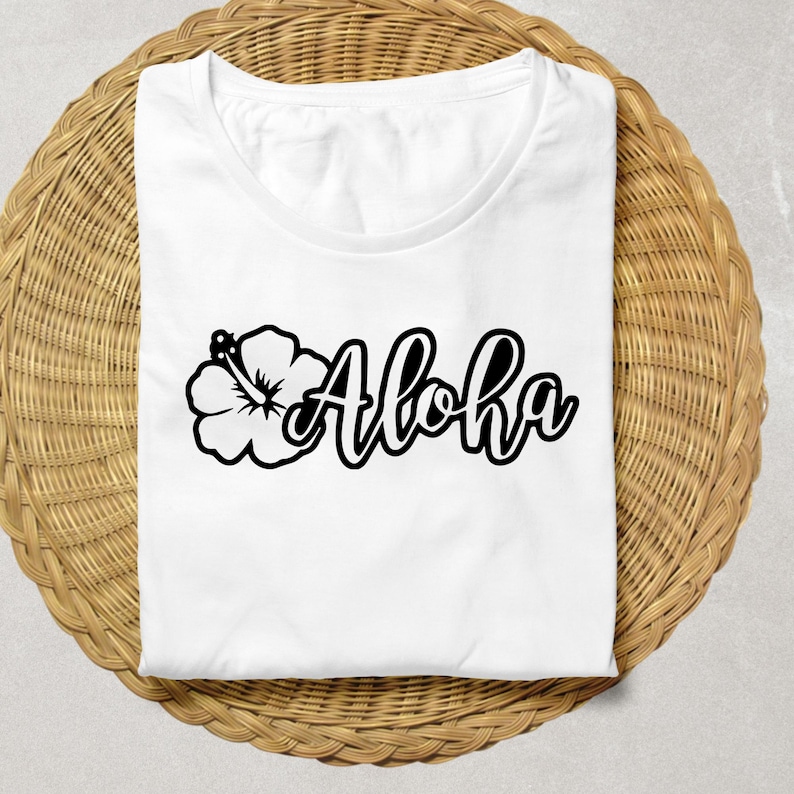 May include: White t-shirt with a black hibiscus flower and the word "Aloha" in a stylized font.