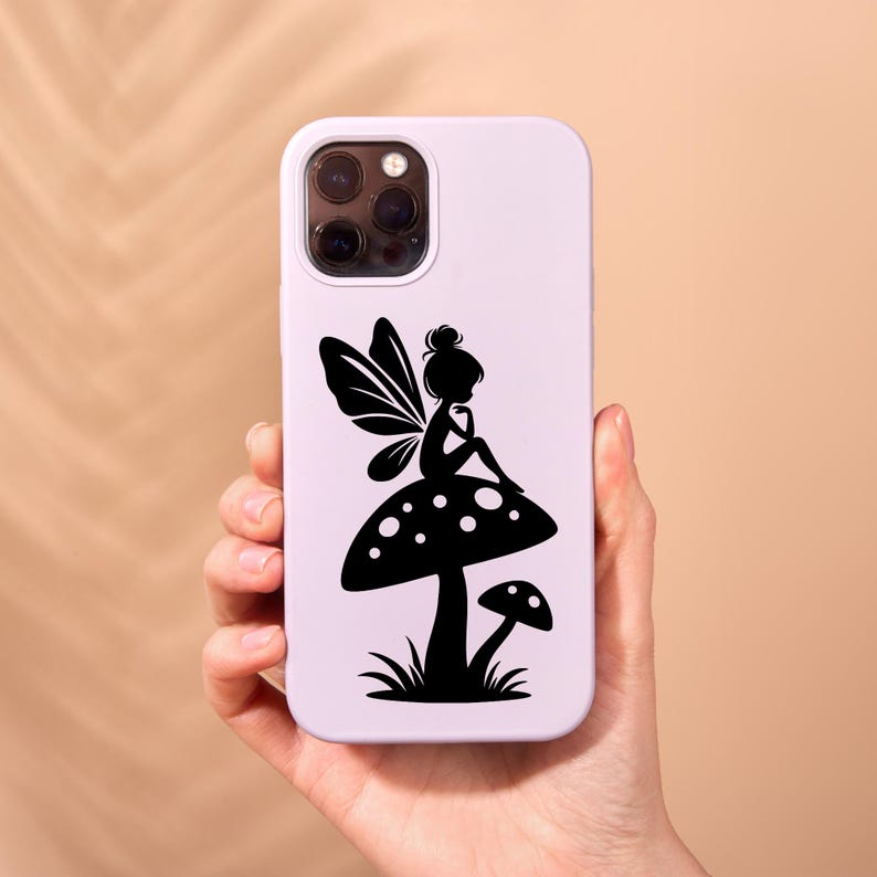 Op de afbeelding: Een witte telefoonhoes met een zwart silhouet van een fee die op een paddenstoel zit. De fee heeft vleugels en houdt een bloem vast.