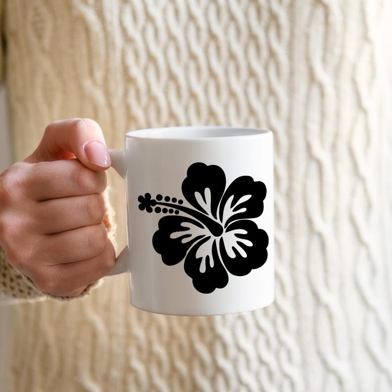 May include: White ceramic mug with a black silhouette of a hibiscus flower.