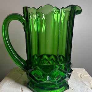 Dit is een groene glazen kan uit het Victoriaanse tijdperk, gemaakt in de 19e eeuw.