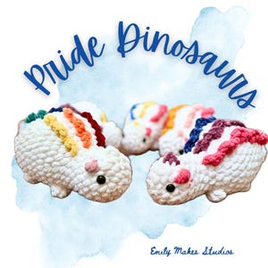 May include: Three white crocheted dinosaur toys with rainbow spines. The text "Pride Dinosaurs" is written in blue script above the toys. The artist's name, "Emily Makes Studios", is written in blue script below the toys.