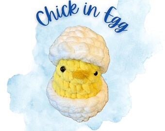 Puede incluir: Un pollito amarillo de ganchillo hecho a mano que emerge de un huevo de ganchillo blanco. El pollito tiene ojos negros y un pico amarillo. El texto "Chick in Egg" está escrito en guión azul encima del pollito. Las palabras "Emily Makes Studios" están escritas en guión azul debajo.