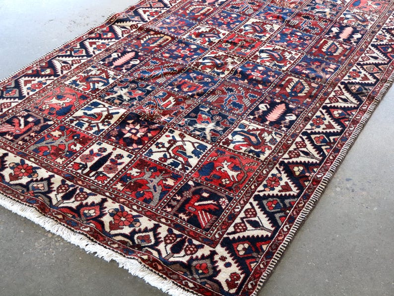 a large, colorful rug with intricate patterns and designs, placed on a concrete floor.