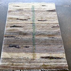 a rug with a geometric pattern and a vertical green line running through it, placed on a concrete floor.