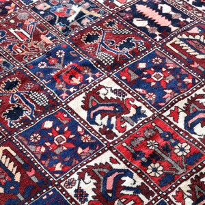 The image is a close-up of a vibrant, intricately patterned rug with a variety of colors and designs.