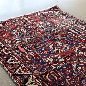 a large, colorful rug with intricate patterns and designs, placed on a concrete floor.