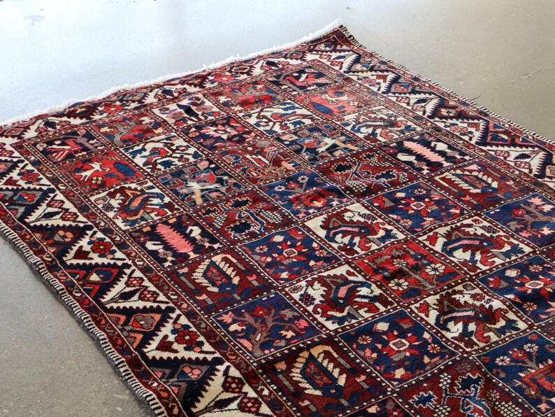 a large, colorful rug with intricate patterns and designs, placed on a concrete floor.