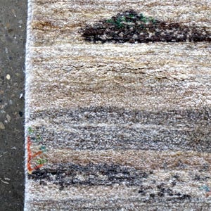 a close-up view of a rug with a geometric pattern, placed on a concrete floor.
