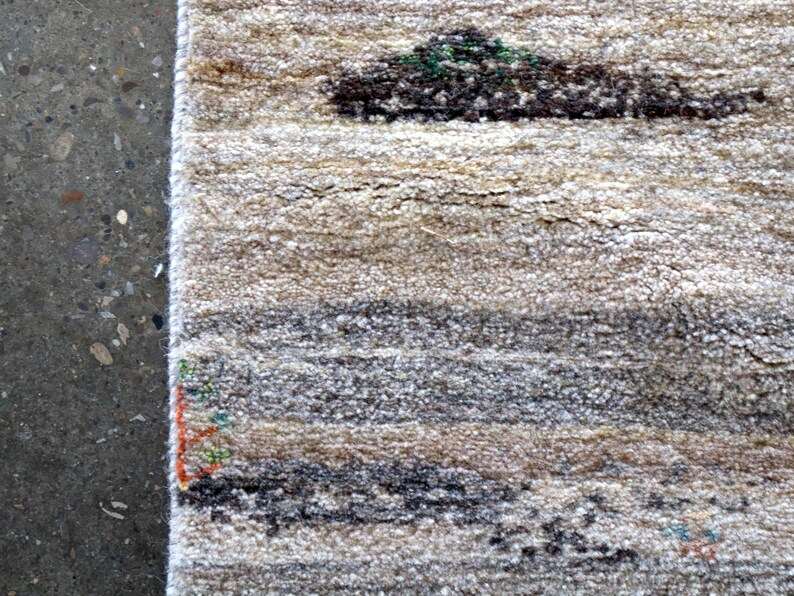 a close-up view of a rug with a geometric pattern, placed on a concrete floor.