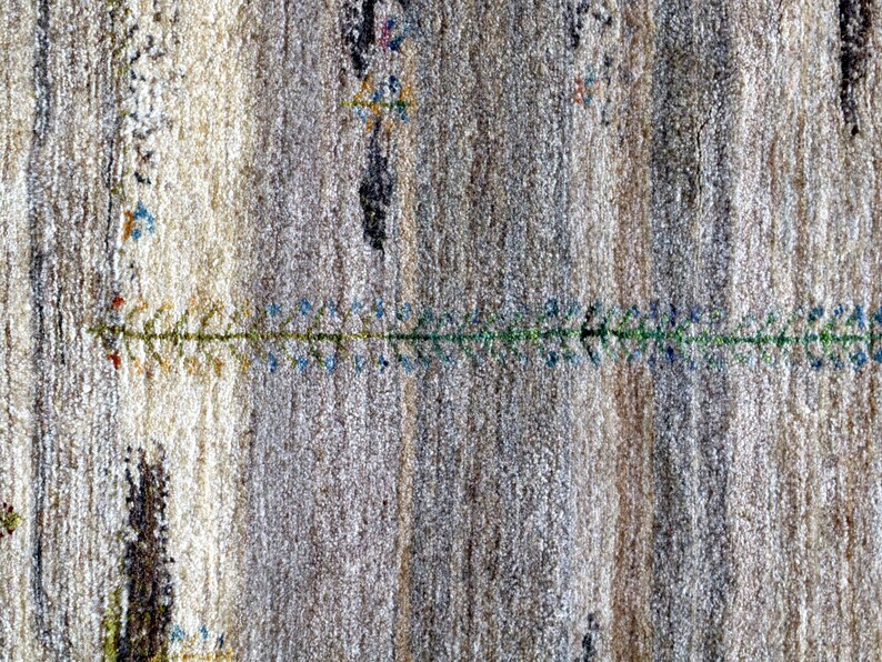 The image is a close-up of a textured surface with a pattern of vertical lines and small green and blue designs.