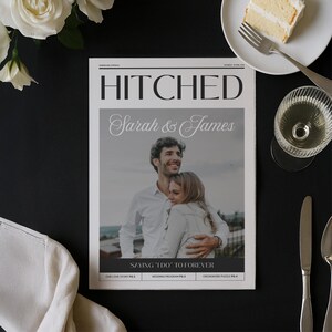 Może przedstawiać: Magazyn ślubny zatytułowany "HITCHED" z nazwiskami "Sarah & James" na okładce. Magazyn zawiera zdjęcie obejmującej się pary. Kawałek ciasta, kieliszek wina i sztućce ułożone są na czarnej powierzchni.