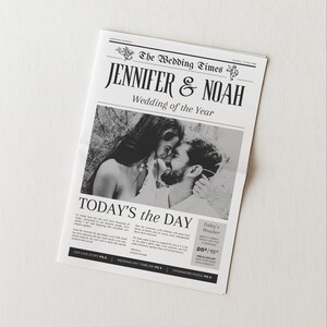 Może przedstawiać: Ogłoszenie ślubne w stylu gazety zatytułowane "The Wedding Times" z imionami "Jennifer & Noah" i nagłówkiem "Wedding of the Year". Czarno-białe zdjęcie przedstawia parę obejmującą się. Tekst brzmi "Today's the Day".