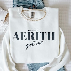 May include: White sweatshirt with black text that reads "NO HEALING AERITH got me".