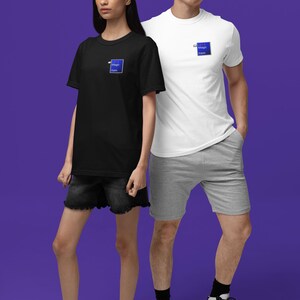 May include: A black t-shirt and a white t-shirt, each with a small blue square logo that reads "Magic Item". The models are wearing black denim shorts and gray shorts. The background is a solid purple.