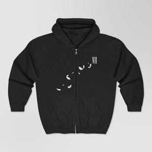 May include: Black zip-up hoodie with a white feather design and the Roman numeral VII printed on the upper right chest. The hoodie has a hood and two front pockets. The zipper is silver.