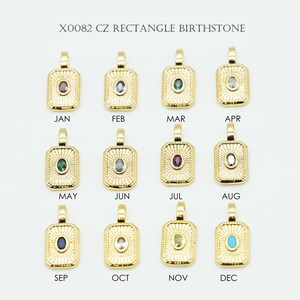 May include: Gold-colored rectangular pendants, each with a different colored gemstone, are displayed. The pendants are labeled with the months of the year, from January to December. The text "X0082 CZ RECTANGLE BIRTHSTONE" is at the top.