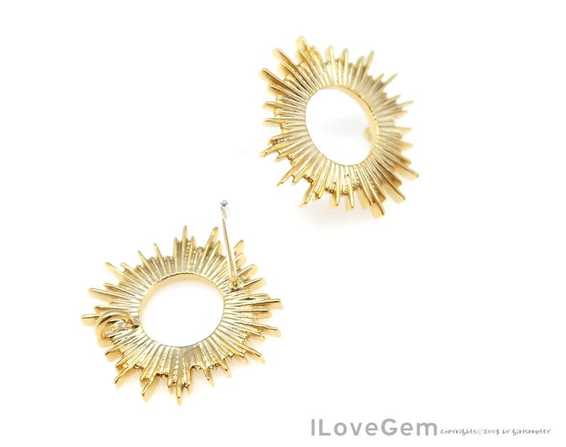 K&ouml;nnte beinhalten: Ein Paar goldene Sonnenstrahlen-Ohrringe mit einem runden Design. Die Ohrringe haben einen Stiftverschluss.