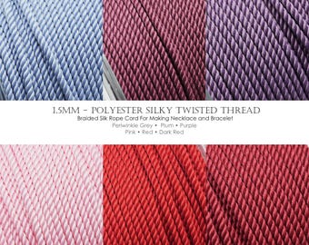 May include: A collection of 1.5mm polyester silky twisted threads in six distinct colors: periwinkle grey, plum, purple, pink, red, and dark red. The braided silk rope cord is presented in a grid layout, showcasing the texture of the twisted strands.