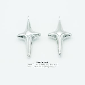 May include: Two polished, silver-coloured puffy star-shaped charms. The charms are made of stainless steel and measure 1.45 x 2.7 cm including the loop. The image text reads "Stainless Steel PUFFY STAR SHAPE CHARM Size: 14.5 X 27 mm (inclduing the loop)".
