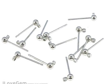 Puede incluir: Un juego de 10 postes de pendientes de plata con bolas redondas en la parte superior. Los postes son rectos y tienen un acabado liso.
