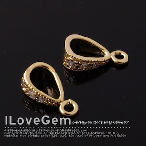 Pode incluir: Dois bailes de pingente dourados com detalhes em cristal transparente. Os bailes têm a forma de uma lágrima com um pequeno laço na parte superior.