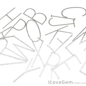 May include: A set of silver metal letters of the alphabet. The letters are scattered on a white background.