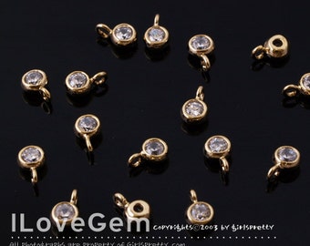 May include: A scattering of gold-toned metal charms with clear crystal stones. Each charm has a small loop for attaching to jewelry or other crafts.