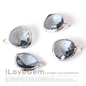 May include: Four silver-toned metal charms with clear faceted glass stones in a teardrop shape. Each charm has a loop for attaching to a necklace or bracelet.