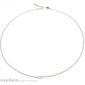 May include: A silver chain necklace with a simple, delicate design. The chain is made of small, round links and has a lobster clasp closure.