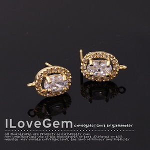May include: Two gold-tone earring findings with a clear oval-shaped stone surrounded by smaller clear stones.