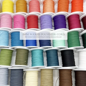 Peut inclure: Plusieurs bobines colorées de cordon en polyester ciré de 1 mm. Les bobines sont disposées en rangées, présentant une variété de couleurs, notamment le jaune, l'orange, le rose, le bleu, le vert et le marron. Le texte sur l'image indique "1MM WAXED POLYESTER CORD".