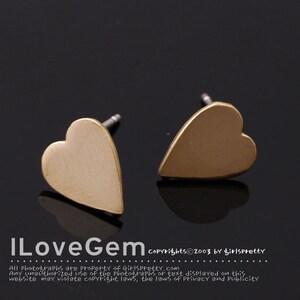 May include: A pair of gold heart-shaped stud earrings. The earrings are simple and elegant, and would make a great gift for a loved one.