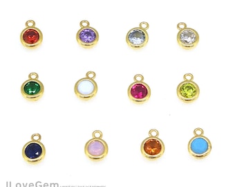 May include: Assortment of 10 gold-tone charm pendants with different colored gemstones. Each pendant features a round gemstone in a bezel setting. The gemstones include red, green, purple, blue, white, pink, yellow, and turquoise.