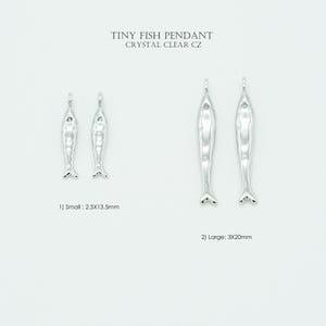 Può includere: Ciondoli a forma di pesce color argento con pietra CZ trasparente. L'immagine mostra due misure: piccolo 2,5 mm x 13,5 mm e grande 3 mm x 20 mm. Il testo recita "TINY FISH PENDANT CRYSTAL CLEAR CZ."
