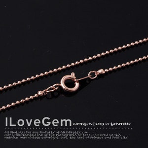 Peut inclure: Un collier en chaîne à billes en or rose avec une fermeture à mousqueton. La chaîne est composée de petites perles rondes.