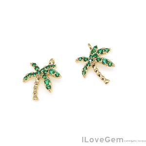 May include: Two gold palm tree charms with green crystal accents. The charms are perfect for jewelry making or adding a tropical touch to crafts.