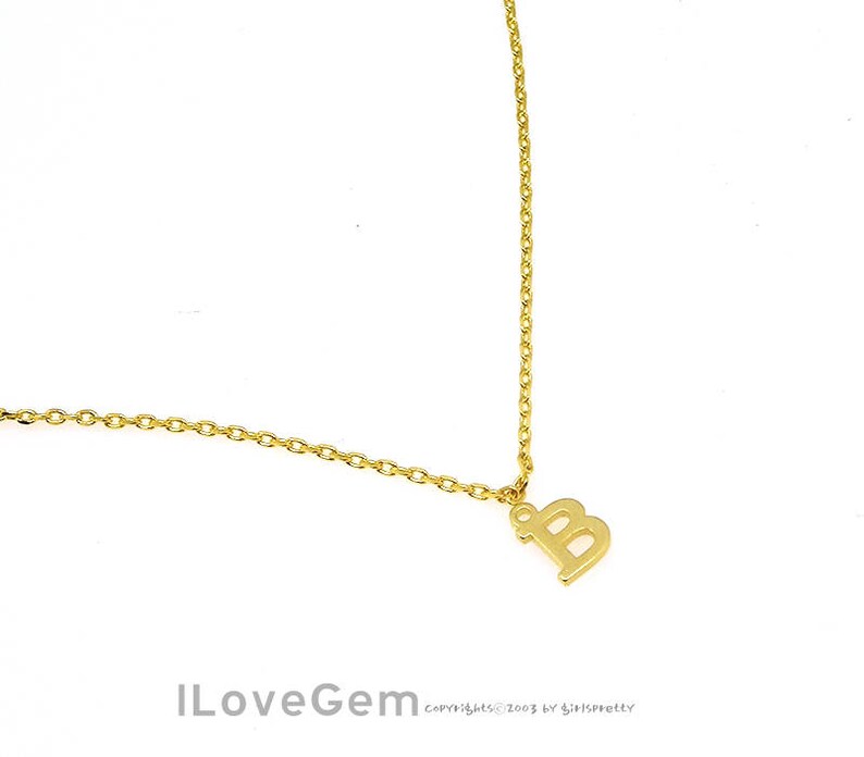 May include: A gold chain necklace with a letter B pendant.