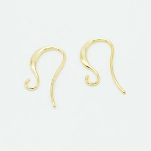 May include: A pair of gold-toned earring hooks with a smooth, curved design. Each hook features a rounded loop at the bottom for attaching jewelry components and a long, tapered wire that curves upward to form the main ear wire structure.