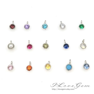 May include: Assortment of 15 silver charm pendants with different colored gemstones. Each pendant features a round gemstone surrounded by a silver border.