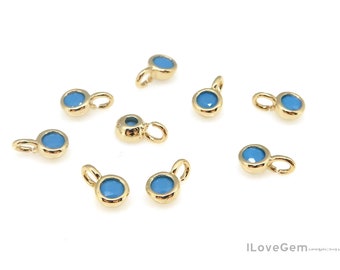 May include: Eight gold-toned charms with blue enamel round accents. Each charm has a loop for attaching to a necklace or bracelet.