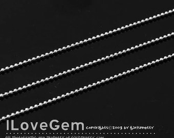 May include: Three silver ball chain necklaces on a black background. The chains are made of small, round beads.