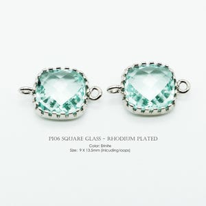 Può includere: Due connettori quadrati in vetro color Erinite con montatura rodiata. Ogni connettore presenta una pietra di vetro verde chiaro sfaccettata e una cornice in metallo argentato. Dimensioni: 9 x 13,5 mm, anelli inclusi.