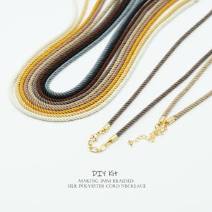 May include: An assortment of braided silk polyester cord necklaces in shades of white, yellow, brown, and grey. The necklaces are 3mm thick and have gold-coloured clasps. Text at the bottom reads "DIY Kit" and "MAKING 3MM BRAIDED SILK POLYESTER CORD NECKLACE."