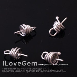 May include: Four silver metal wire coil bead caps with a loop on one end and a small ball on the other end. The caps are designed to be used for jewelry making.