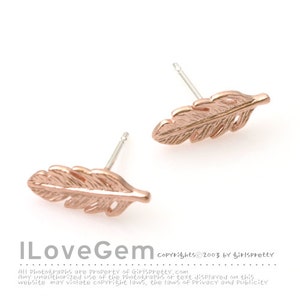 May include: A pair of rose gold feather earrings. The earrings are small and delicate, with a simple design.