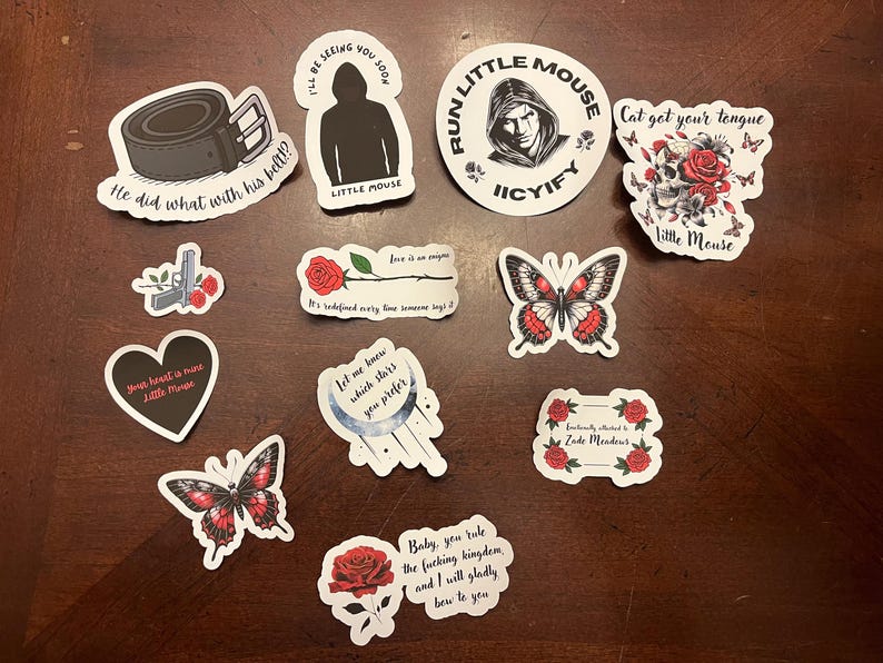May include: A set of ten stickers featuring various designs, including butterflies, flowers, hearts, and text. The stickers are printed on white paper with black outlines and red accents.