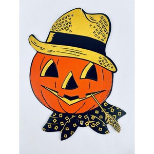 May include: Vintage Halloween decoration featuring a smiling jack-o'-lantern head with a straw hat and a black scarf with yellow diamond patterns. The pumpkin is orange with black eyes and a mouth. A straw is in its mouth.