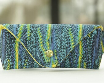 May include: A blue and green patterned fabric eyeglass case with a yellow trim and a gold button closure.