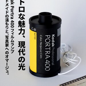 May include: A black Kodak Portra 400 film lamp with a yellow stripe and white cord. The lamp has text in Japanese and English. The lamp is a handmade homage to photographers.