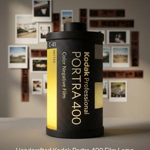 May include: A black Kodak Portra 400 film lamp with the text "VINTAGE SOUL, MODERN LIGHT" at the top. The lamp has a yellow glow and is surrounded by framed photos. The text "Handcrafted Kodak Portra 400 Film Lamp" is at the bottom.